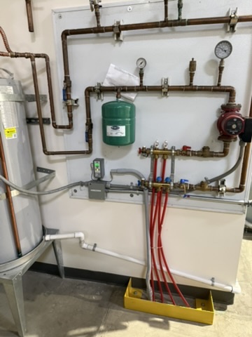 DCW installed freezer underfloor heating system with copper piping, expansion tank, and manifold
