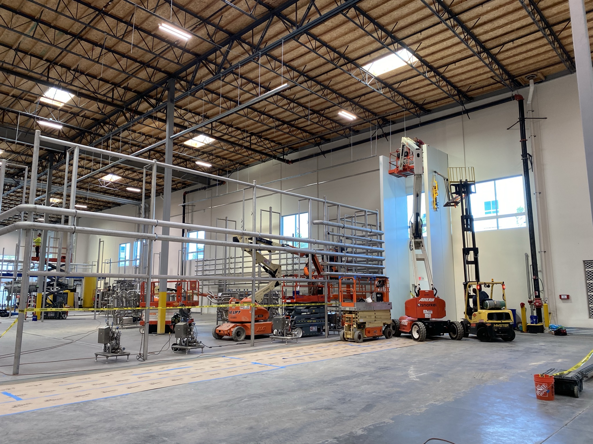 DCW crews and lift equipment working on large commercial facility buildout
